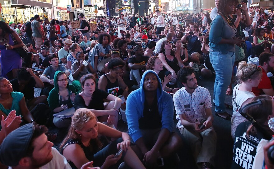 Trayvon Martin supporters sit in New York City's Times Square on Sunday after marching from a rally for Martin in Manhattan.