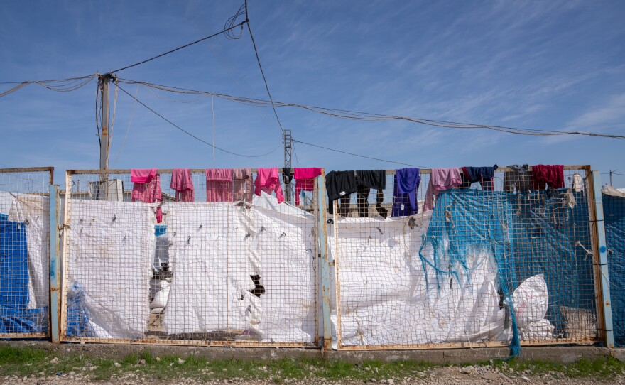 Laundry hangs on the top of a metal fence at Roj.