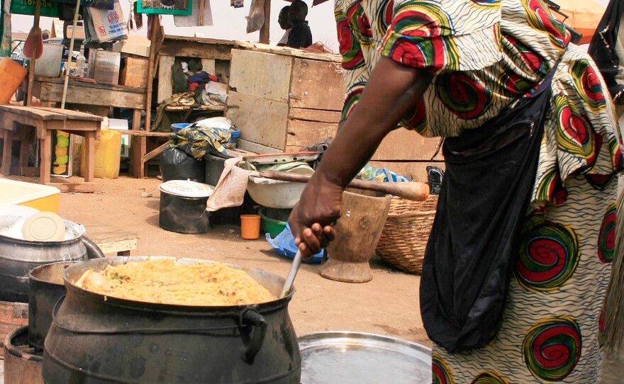 A food vendor in Kano, Nigeria, prepares jollof rice outdoors in an iron pot. When it comes to jollof, my Nigerian friend Ronke Onadeko argues, "the taste of perfection is smoke-flavoured."