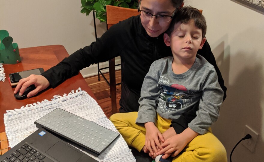 Julia Najera attempts to work from home with her son in her lap in this undated photo.