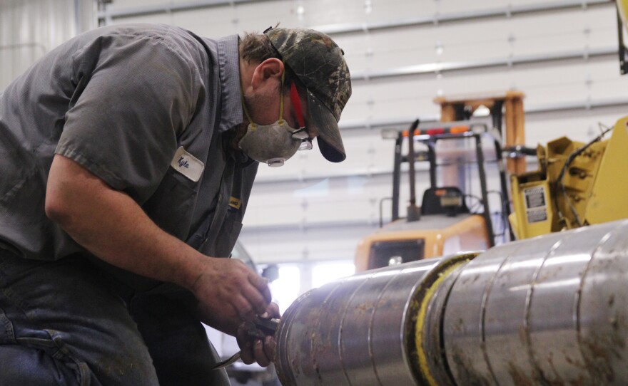 Kyle Garman, a technician at the the New Holland dealership in East Havana, Ill., takes apart the feeder head on a large combine. Owner Frank Hofreiter says farm customers are opting to repair old equipment rather than buy new.