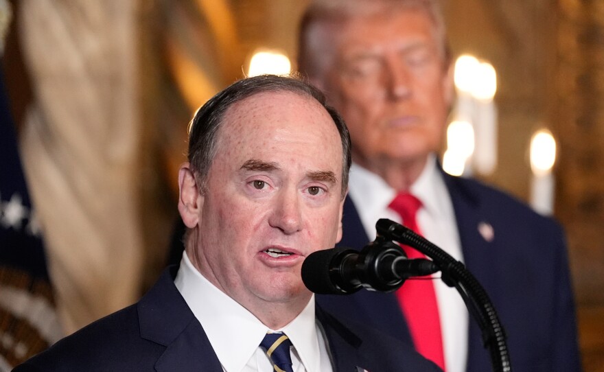 Secretary of the Navy John Phelan speaks, as President Trump listens, at Trump's Mar-a-Lago club on Dec. 22 in Palm Beach, Fla.