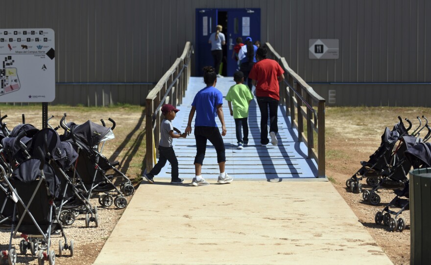 Immigrants walk into a building at South Texas Family Residential Center in Dilley, Texas.
