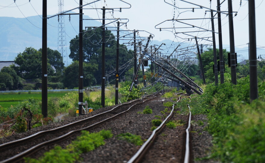 Electric poles are seen fallen over rail tracks in Hikawa, southern Japan, Thursday, July 30, 2026, two days after an earthquake hit the area.