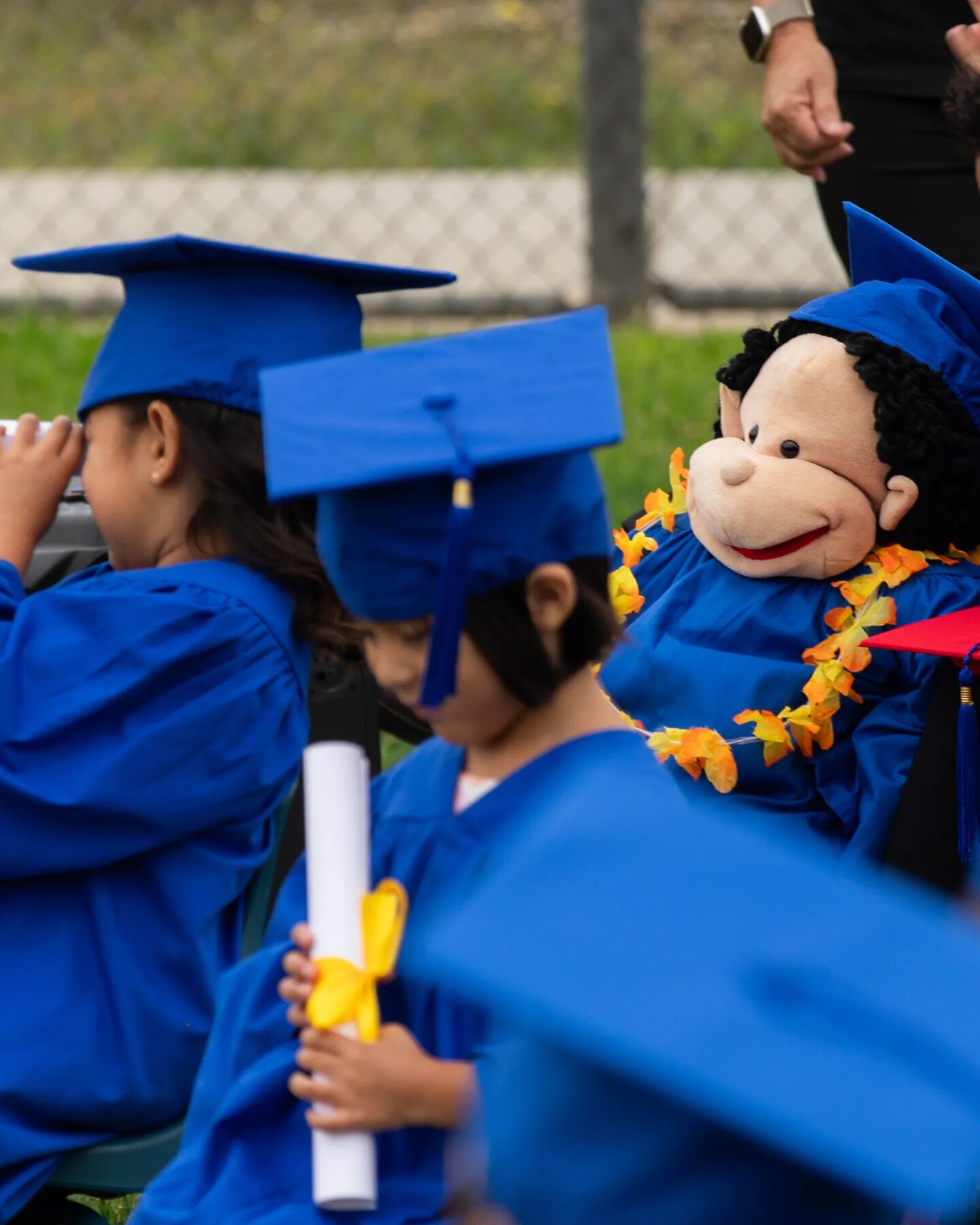 Puppet Wally sits with students during the school’s graduation ceremony on June 11, 2025. Puppets are used to act out scenarios that help students learn about different emotions and how they can interact with others.