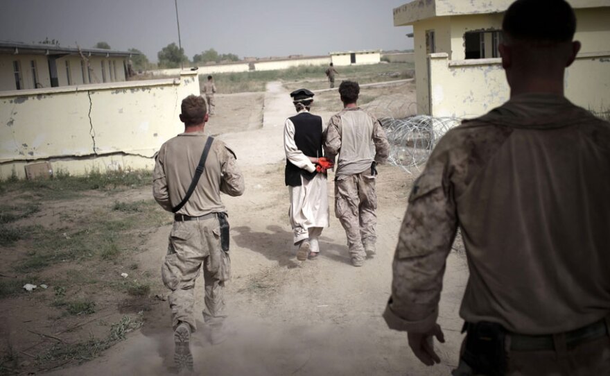 U.S. Marines lead an Afghan detainee toward their combat outpost for questioning in a Taliban stronghold area in Marjah, Helmand province, southern Afghanistan, April 1, 2010. The leak of more than 90,000 secret military intelligence reports on the war in Afghanistan paints a grim and often discouraging picture of the situation on the ground.