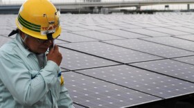 <p>A worker stands next to an array of Sharp solar cell modules at a power plant south of Tokyo in August. Sharp was one of 1,400 solar panel manufacturers in attendance at the Solar Power International conference, where industry optimism was high.</p>