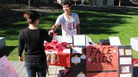 A volunteer at UCSD hands a student a condom rose in honor of World AIDS Day. Health officials say young adults, especially minorities, are at risk for HIV infection.