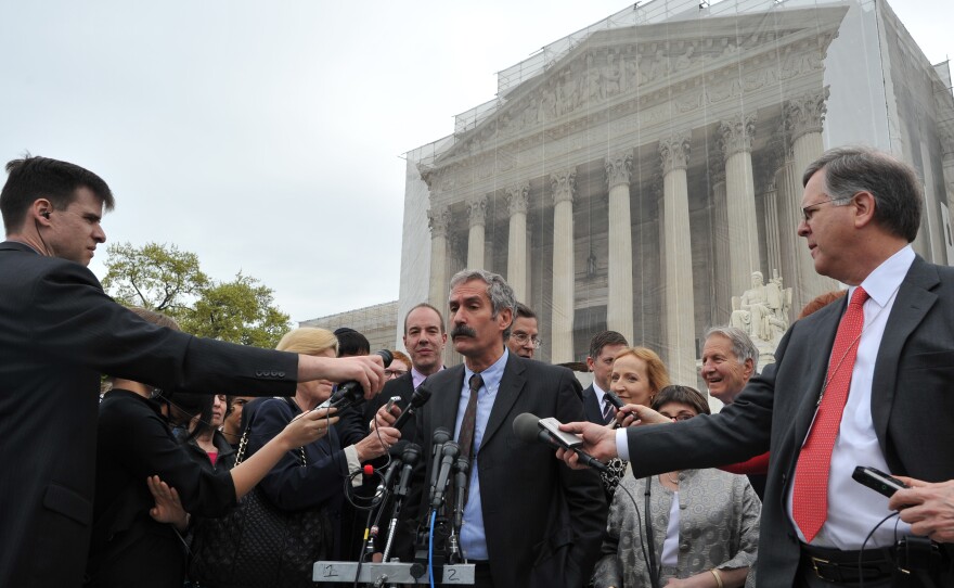 Medical geneticist Dr. Harry Ostrer (center) talks to the press outside the U.S. Supreme Court on Monday. The court heard oral arguments on the highly charged question of whether human genes can be patented.