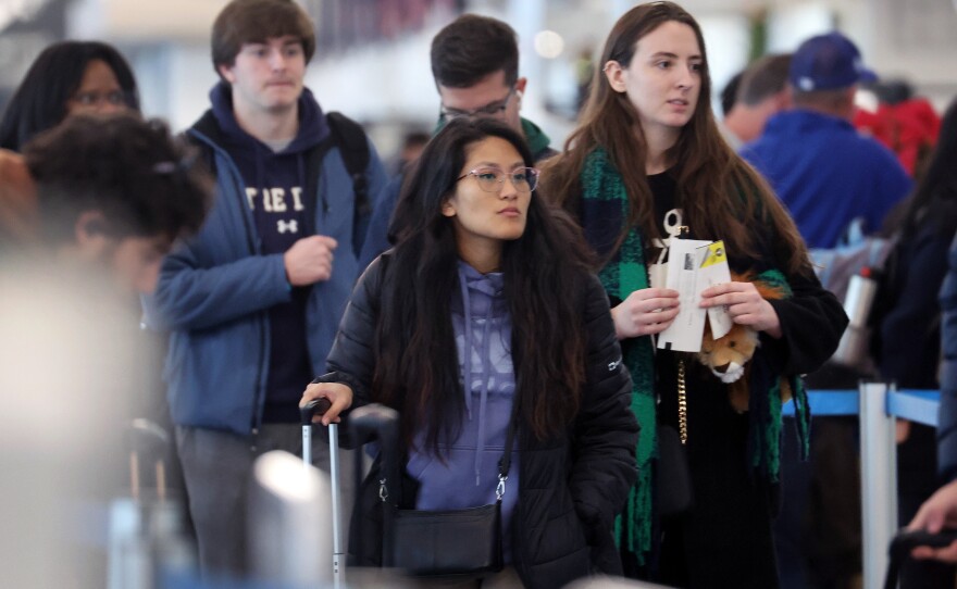 Travelers arrive for flights at the O'Hare International Airport, in Chicago, on December 16.