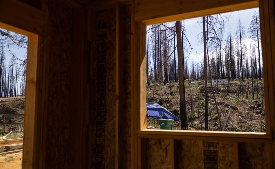 A tent and RV can be seen in the distance from a home being rebuilt from the Caldor Fire, Thursday, August 4, 2022.