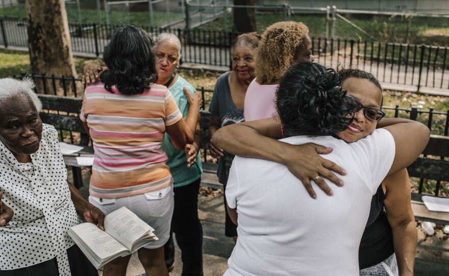 Former parishioners of Our Lady Queen of Angels wish each other peace during a service on a recent Sunday morning.