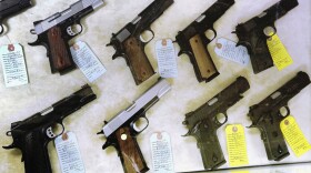 In this July 10, 2013 file photo, semi-automatic handguns are seen display for purchase at Capitol City Arms Supply in Springfield, Ill. 