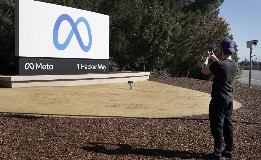 Facebook employee take a photo in front of new Meta Platforms Inc. sign outside the company headquarters in Menlo Park, Calif., Thursday, Oct. 28, 2021.