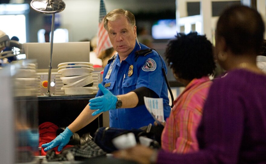 A TSA officer screens airline passengers at the Dallas/Fort Worth International Airport on Sunday. Preflight screenings were stepped up after a man was accused of trying to blow up a Northwest Airlines flight Friday.