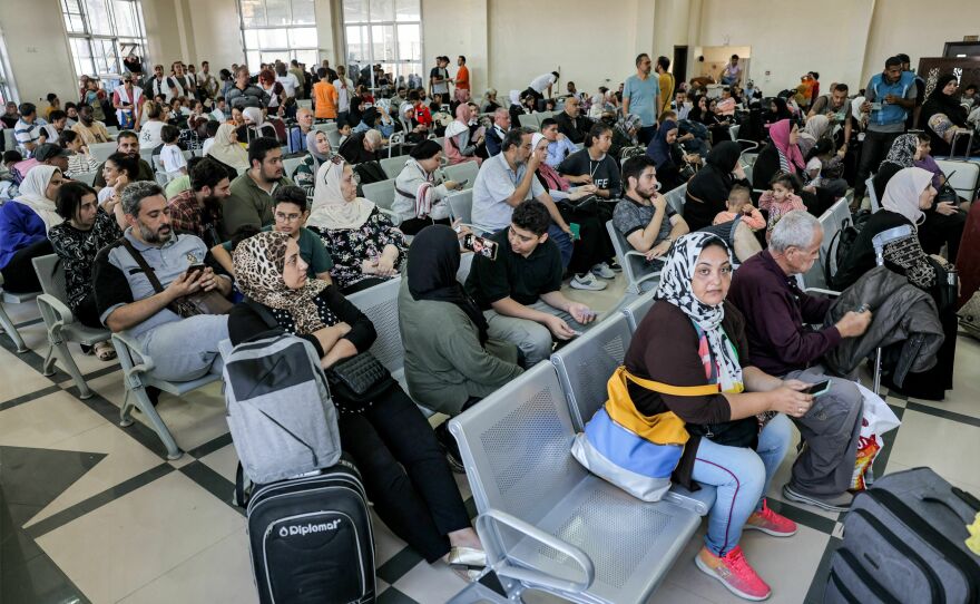 People sit in the waiting area at the Rafah border crossing in the southern Gaza Strip before crossing into Egypt on Wednesday.