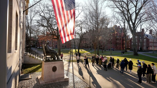 FILE - People take photos near a John Harvard statue, left, on the Harvard University campus, Jan. 2, 2024, in Cambridge, Mass.
