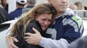 Man holds woman as they wait at a church on Friday where students were taken to be reunited with parents following a shooting at Marysville Pilchuck High School in Washington. 