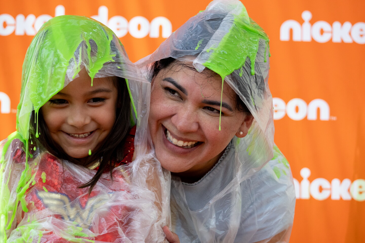 A child and their mother smile after being slimed at the Nickelodeon pop-up during Comic-Con, July 24, 2026.
