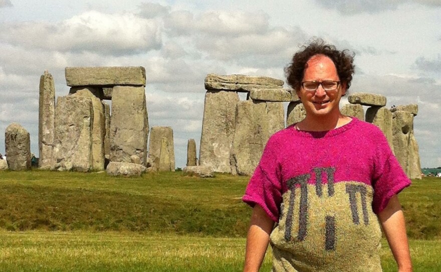 Wearing the appropriate attire, knitter Sam Barsky stands in front of Stonehenge.