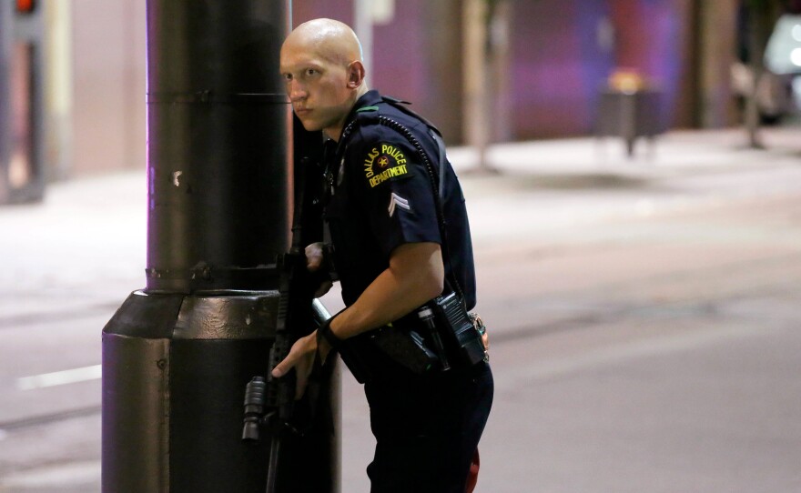 A Dallas policeman keeps watch on a street in downtown Dallas on Thursday.