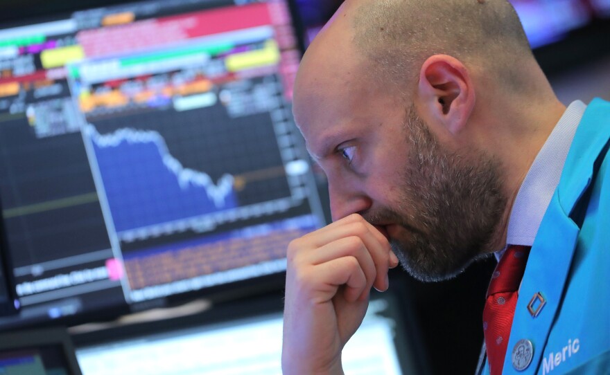 A trader works on the floor at the New York Stock Exchange on Tuesday, when the Dow Jones industrial average fell 799 points. Stock markets continued to fall on Thursday.