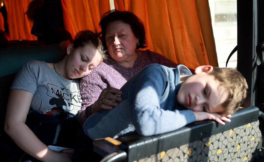 Passengers from Mariupol wait on a bus on Tuesday after arriving safely on a train to Lviv, Ukraine.