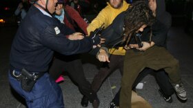 A Chicago police officer scuffles with opponents of the city's bid for the 2016 Olympics in Daley Plaza on Tuesday.