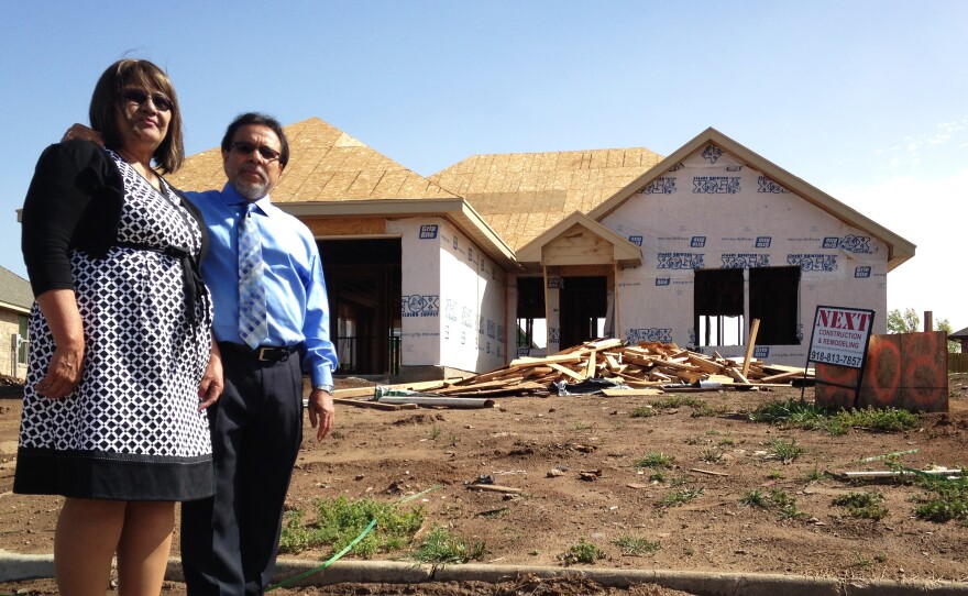 Gloria and Francisco Sanchez stand in front of their new ranch house, still under construction a year after a tornado destroyed their last home in Moore, Okla.