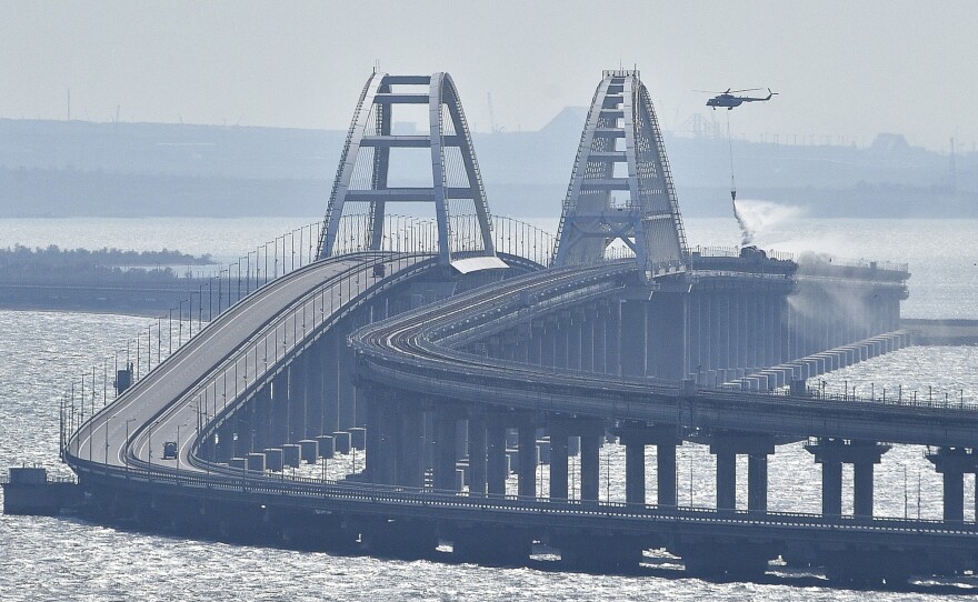 A helicopter drops water to stop fire on Crimean Bridge connecting the Russian mainland and Crimean peninsula over the Kerch Strait on Saturday.