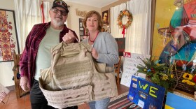 Walter Scranton and Alla Boyko pose with a bullet proof vest Scranton just donated to help protect civilians in Ukraine during a collection drive at the House of Ukraine in Balboa Park.