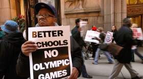 Limmie McMiller stands with demonstrators outside City Hall to protest Chicago's bid for the 2016 Olympics. The International Olympic Committee is scheduled to announce which city will host the games Friday.