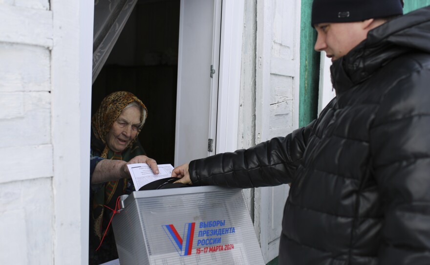 An elderly woman casts a ballot during a presidential election via a mobile election committee, who visit people who cannot physically attend a polling station, in Nikolayevka village outside Siberian city of Omsk, 2236 km (1397 miles) east of Moscow, Russia, on Saturday.