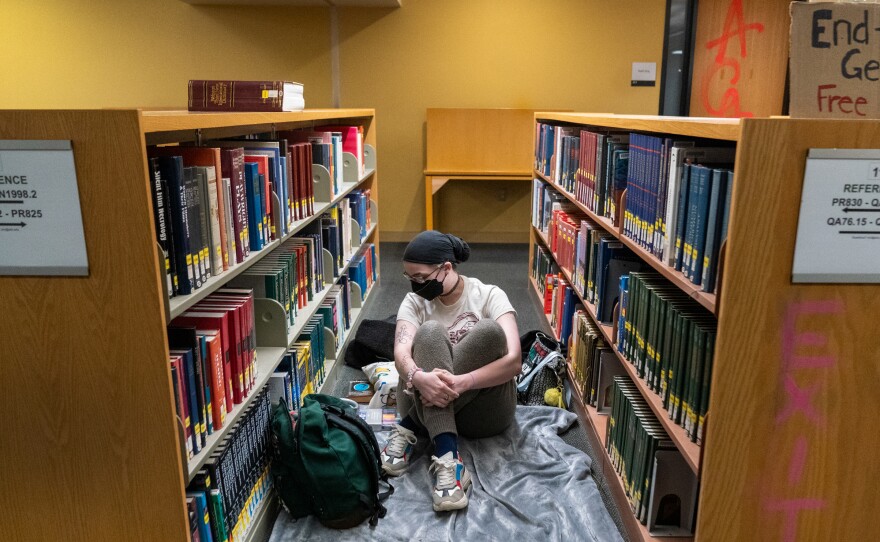 A person prepares to rest for the evening in the library, inside the occupied Branford Price Millar Library at Portland State University on April 30. All books were shelved and no books were seen damaged or disturbed.
