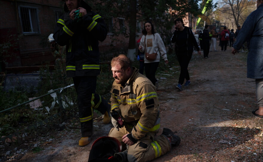 A rescue worker sits on the ground next to a residential building destroyed in a Russian missile strike on Pryluky, Ukraine, Wednesday, Oct. 7, 2026.