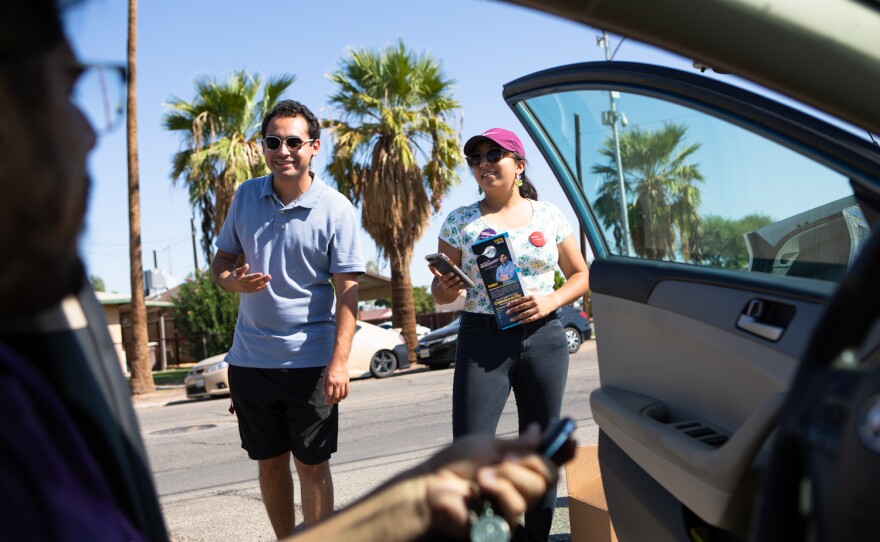 Gilberto Manzanarez talks with Raul Ureña and Daniela Flores while campaigning in Calexico, Oct. 8, 2022.