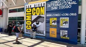 Comic-Con attendees take photos in front of a Comic-Con International sign on July, 23, 2025. 