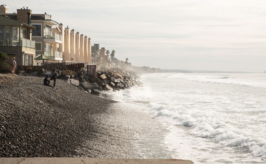 A few people stand on the rocky seashore at Oceanside's Buccaneer Beach, Dec. 18, 2023.