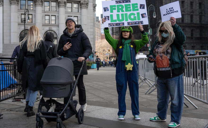 Supporters of Luigi Mangione raise signs outside Manhattan federal court on Jan. 9 in New York.