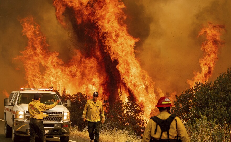 Flames from the LNU Lightning Complex fires leap above Butts Canyon Road on Sunday, Aug. 23, 2020
