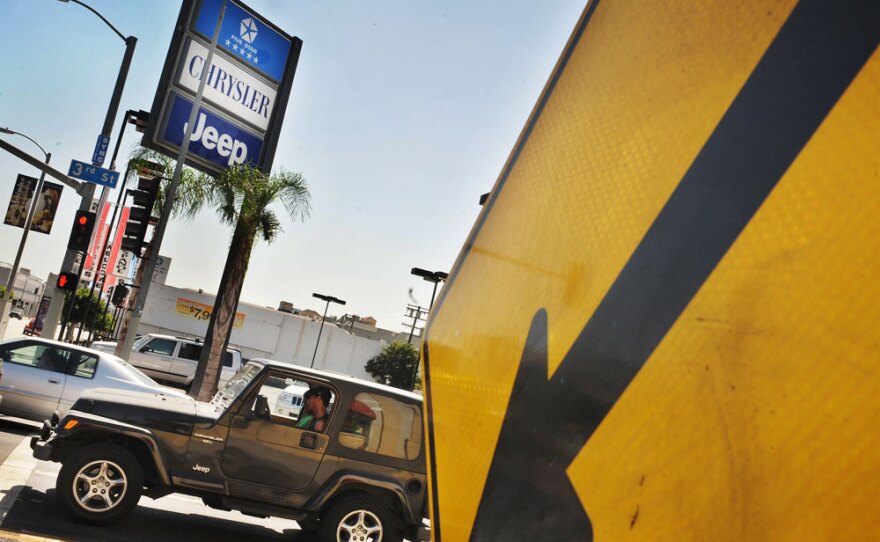 A Chrysler Jeep drives past a dealership in Los Angeles last year. The company, now part of Fiat, is trying to compete with other automakers that have deper pockets and more new cars to sell.