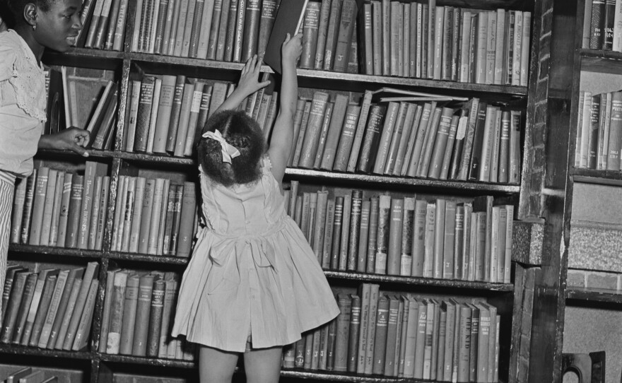 A child reaches for a book at a branch of the Brooklyn Public Library in August 1950.