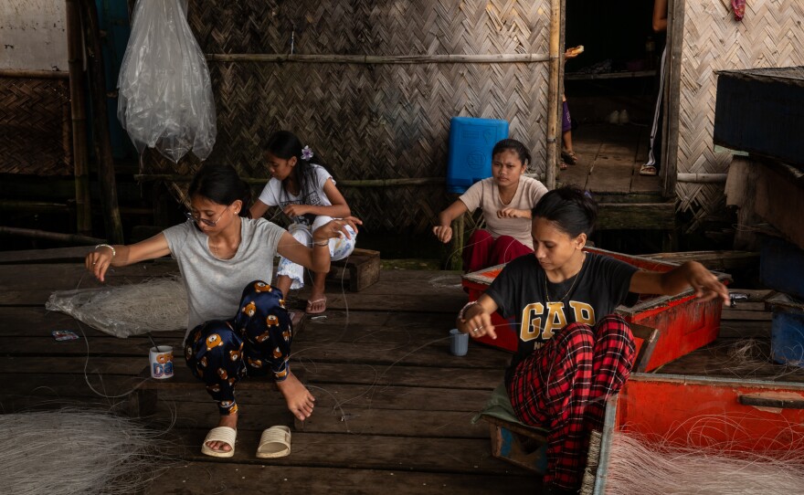 Family members of Filipino fishermen place bait on fishing lines in Quezon, Palawan, the Philippines, on May 24, 2025.