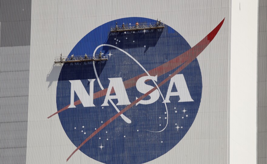 Workers near the top of the 526 ft. Vehicle Assembly Building at the Kennedy Space Center spruce up the NASA logo standing on scaffolds in Cape Canaveral, Fla., Wednesday, May 20, 2020.