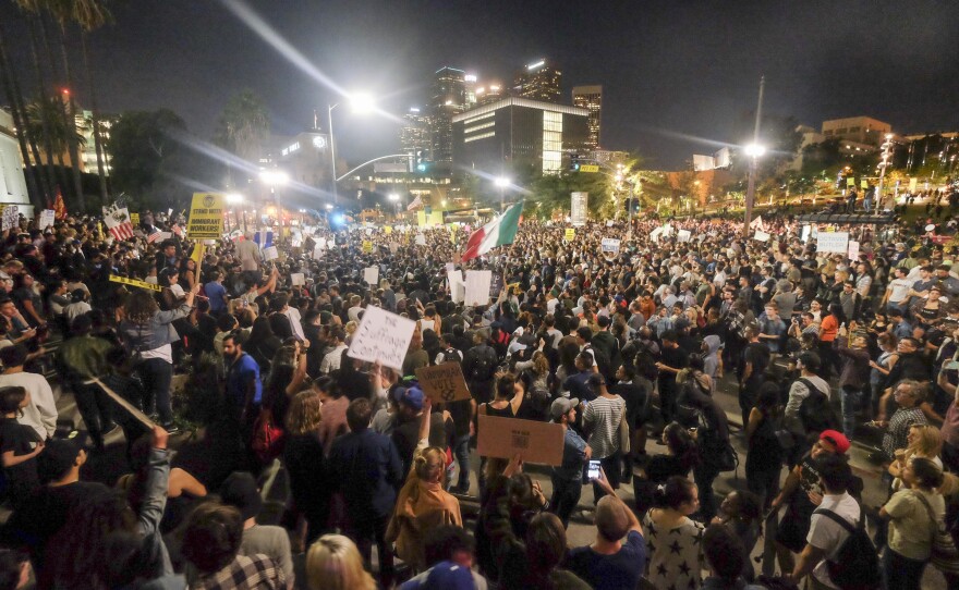 Demonstrators gather to protest a day after President-elect Donald Trump's victory, at a rally outside Los Angeles City Hall on Wednesday. Protesters burned a giant, orange-haired head of Donald Trump in effigy, lit fires in the streets and blocked traffic lanes late into the night.