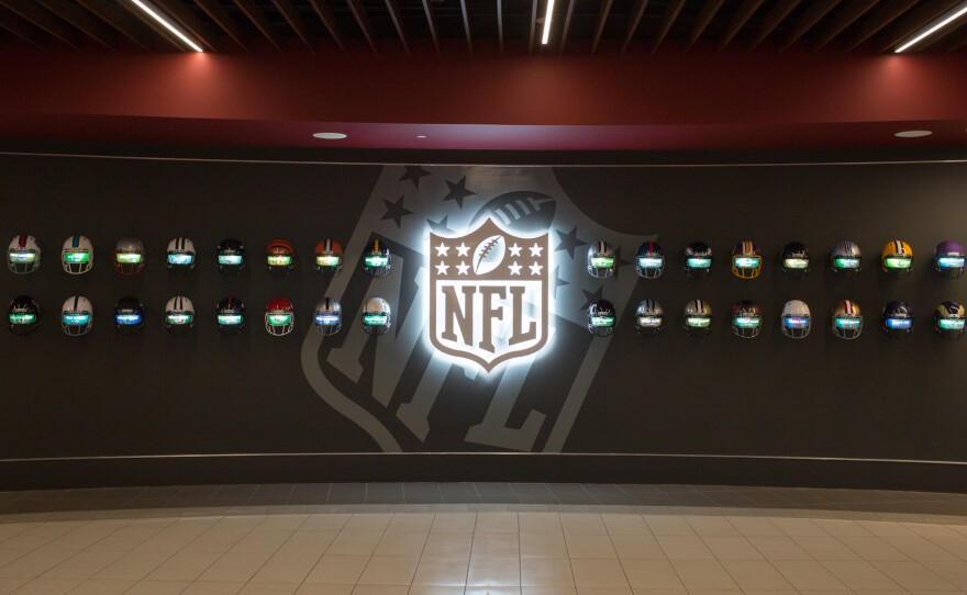 Inside Alabama's "recruiting hall," 32 helmets of every NFL team scroll through the names of Crimson Tide players who have played in the league.