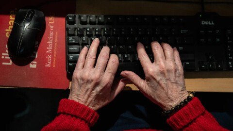 An elderly person types on a keyboard in this undated photo.