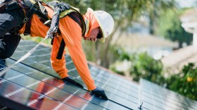 A worker installs rooftop solar panels in this undated photo.