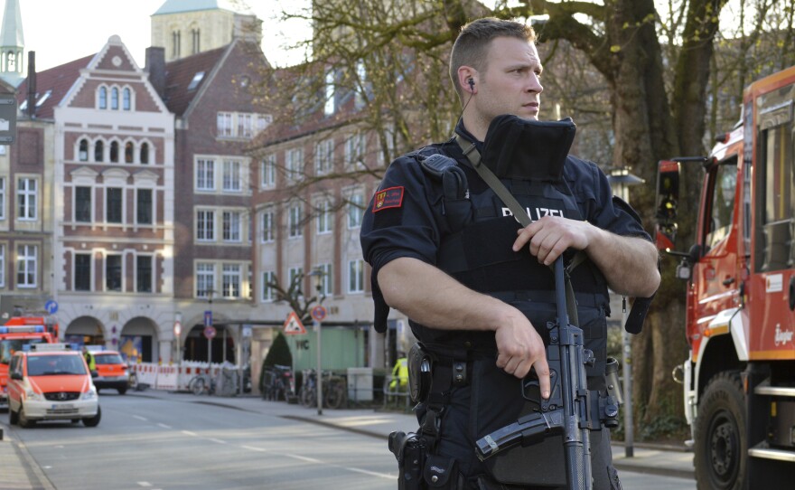 A police officer stands near the scene where a car crashed into a group of people in Muenster, Germany, leaving two dead, before killing himself.