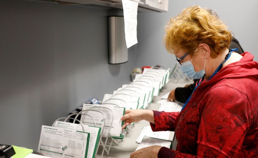 An employee of the West Bloomfield Township Clerks office sorts absentee ballots by the precinct and ballot number at the West Bloomfield Clerks office on October 31, 2020 in West Bloomfield, Mich.